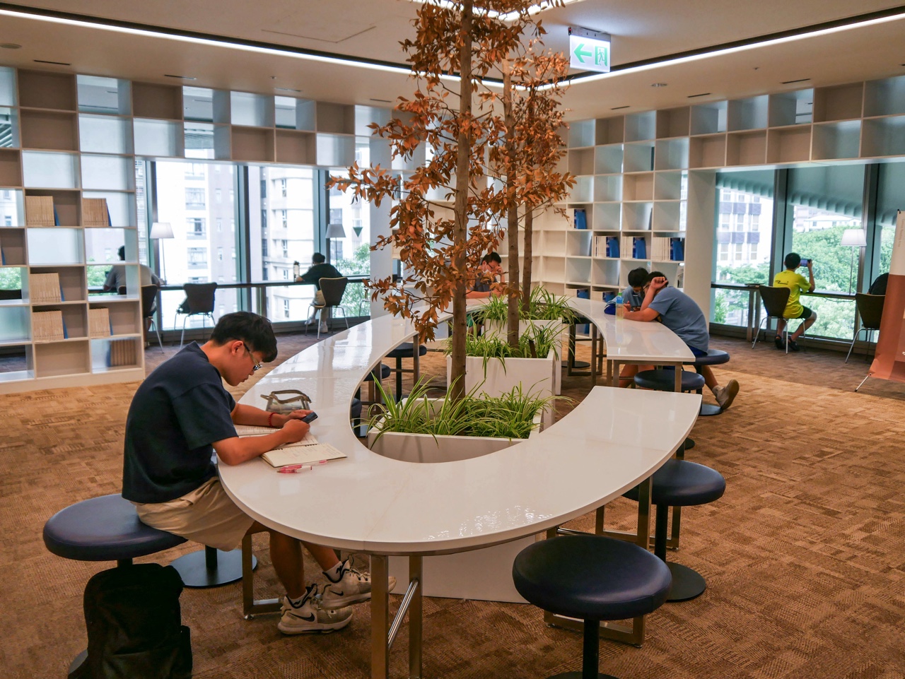 桃園市圖書館新總館の円形テーブルを利用する人々